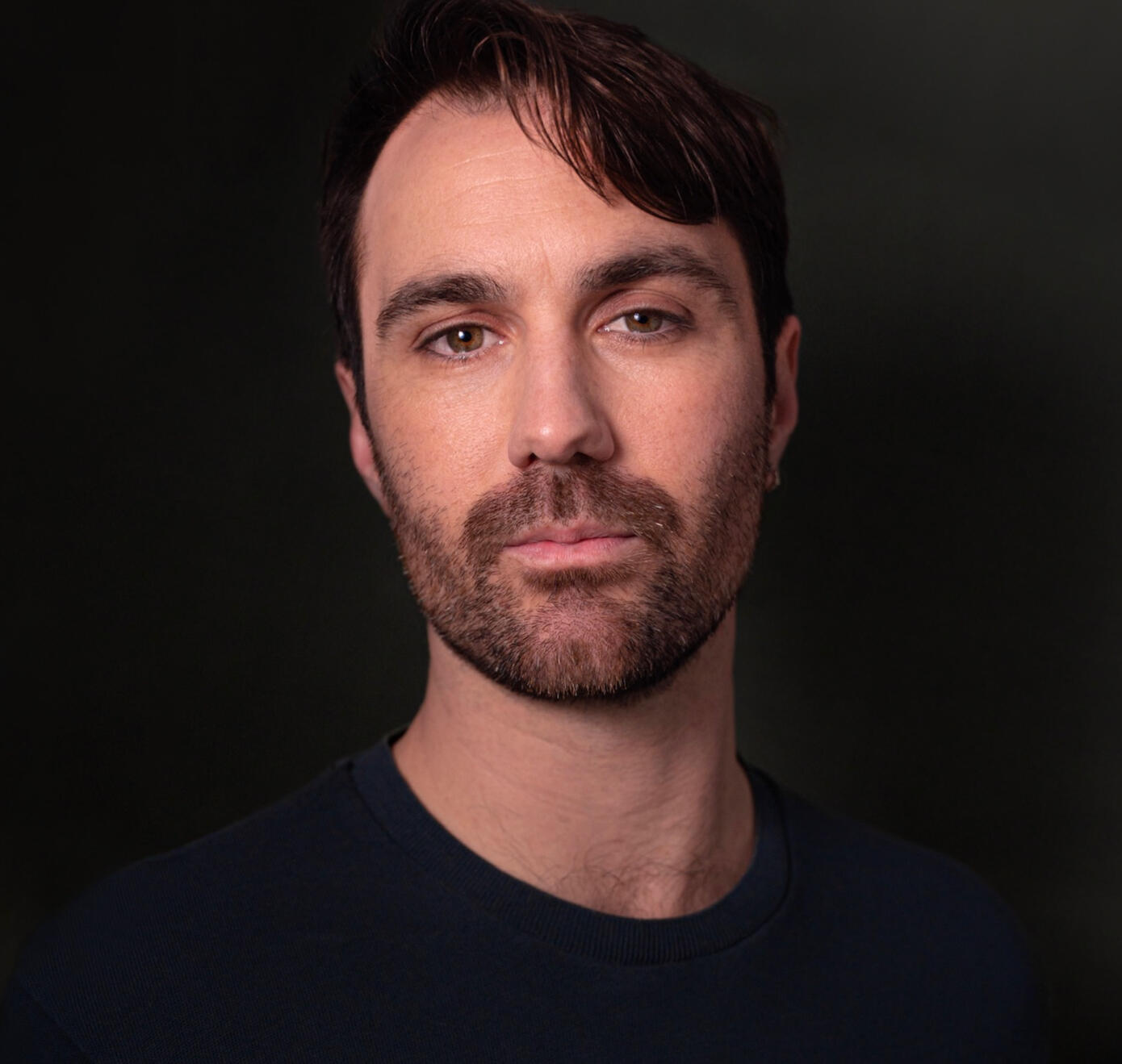 Ryan Pater Headshot of Ryan Pater wearing a black shirt, with a black background